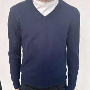 Marinblå Stickad tröja från Hansen & Jacob - Jättefin mörkblå stickad tröja av fårull! Skicket är superfint, viss tecken på användning då den är stickad men inget man ser tydligt! Tröjan är från det Exclusiva märket Hansen & Jacob. Enligt modellen på bilden är tröjan däremot liten i storlek, det står storlek L på tröjan men passar bättre för någon med storleken S/M. För referens har modellen vanligen M/L 
