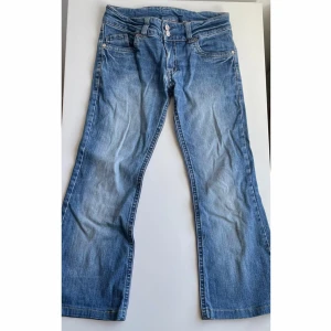 Capribyxa med låg midja - Säljer ett par lågmidjade capribyxor från Detroit i storlek 140. Byxorna har två rosa knappar framtill, lite utsvängda ben och snygga bakfickor med broderad detalj.