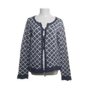 Mönstrad kofta från Rose Bud - Säljer en blå och vit kofta från Rose Bud i storlek M. Koftan har ett klassiskt mönster, långa ärmar och dekorativa kanter. Den knyts baktill med ett band