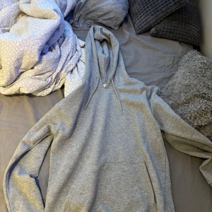 Grå hoodie från Pier One - Säljer en klassisk grå hoodie från Pier One med huva och dragsko. Tröjan har en stor magficka och långa ärmar. Perfekt för en avslappnad stil och enkel att matcha med det mesta. Inte använd 