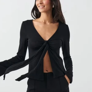 Svart långärmad topp med knyt - Säljer denna supersnygga svarta knyttoppen från Gina Tricot. Inte använd så supermycket. Säljer för jag inte har någon användning för den längre. Storlek Xs och passar någon runt Xs/S och 164-172 lång. 😊Nypris 300kr. Skriv om ni är intresserade eller om ni har några frågor💕