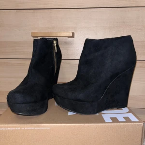 Klack boots - Helt nya klackskor i en super fin modell! Aldrig använt de, endast testade. Står storlek 37 men är mer som en 36/37. Har liten skada vid ena klacken då färgen lossnat lite (se bild). Inget som syns när man har på sig dem. ”Ena kedjan på klacken är lite seg att dra upp”. 