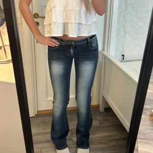 Lågmidjade utsvängda jeans - Jätte fina vintage jeans i jättebra skick! Har jätte coola slitningar. Måtten: Innerben: 84, midja rakt över 38 cm Kom privat för fler mått eller frågor🥰