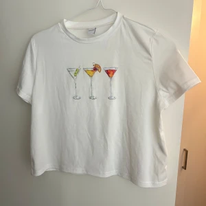 Vit t-shirt med drinkmotiv - Aldrig använd