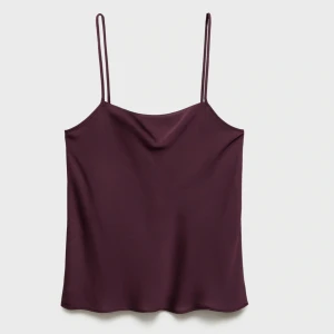 Vinröd satinlinne med tunna axelband - Vinrött linne i satin med tunna axelband och lätt draperad halsringning. Perfekt att styla med både jeans och kostymbyxor. Linnet har en mjuk glans och avslappnad passform. 