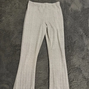 Grå mönstrade utsvängda byxor  - Snygga grå byxor från Primark med  fiskbensmönster. Byxorna har elastisk midja och är bootcut i modellen med lätt utsvängda ben. 