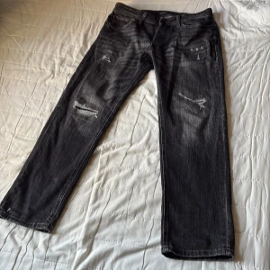 Svarta jeans Jack & Jones  - Säljer ett par svarta jeans med slitningar från Jack & Jones (Mike). Stl 30/30