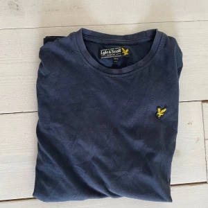 Mörkblå t-shirt från Lyle & Scott - Säljer en marinblå t-shirt från Lyle scott T-shirt! Bra skick, den har ett litet ihop sytt hål. Skriv om ni har några frågor!😁