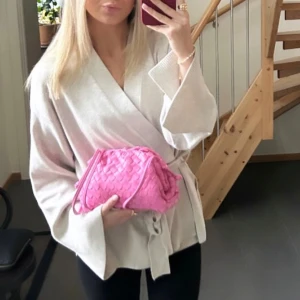 Beige omlottkofta med knytband - Säljer en beige finstickad kofta med knytband i midjan. Koftan har lång ärm med slits. Så himla fin!!🤍