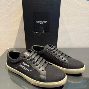 Saint Laurent skor - Säljer ett par svarta Saint Laurent sneakers i storlek 43. Skorna är använda en gång och säljer på grund av att de inte passade mig. Perfekta skor nu inför sommaren som kommer ge dig en clean och stilig look☀️Vid frågor eller funderingar är det bara att höra av sig‼️PRISET är solklart inte skrivet i sten