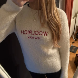Vit fluffig tröja från Woolrich - Säljer en supermjuk och fluffig vit tröja från Woolrich med röd broderad text 'WOOLRICH NEW YORK' på bröstet. Använd ett fåtal gånger så i superbra skick. Storlek 14 år men skulle säga att den sitter som en Xs/S. Pris kan diskuteras 
