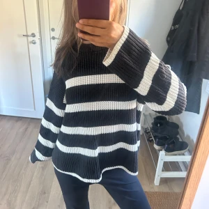 Svartvit randig stickad tröja - Säljer en oversized stickad tröja med breda svarta och vita ränder. Tröjan har lång ärm och en avslappnad passform med ribbade muddar. 