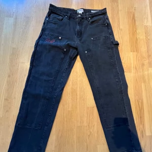 Svarta carpenter jeans från Guess  - Ett par svarta carpenter jeans från Guess x Anna Nicole. Storlek 32. Dom är i fint skick också 