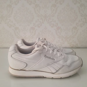 Vita Reebok sneakers  - Vita Reebok sneakers i storlek 37,5. Modellen har rund tå, snörning och platt sula. Skorna är i det stora hela i fint skick.