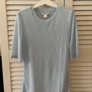 Ljusblå ribbad topp från Monki - Supersöt ljusblå ribbad topp från Monki. Tunt och lätt material som är lite transparent, perfekt för sommaren. Enkel och stilren design som funkar till allt. Hör gärna av er vid frågor eller intresse!😊