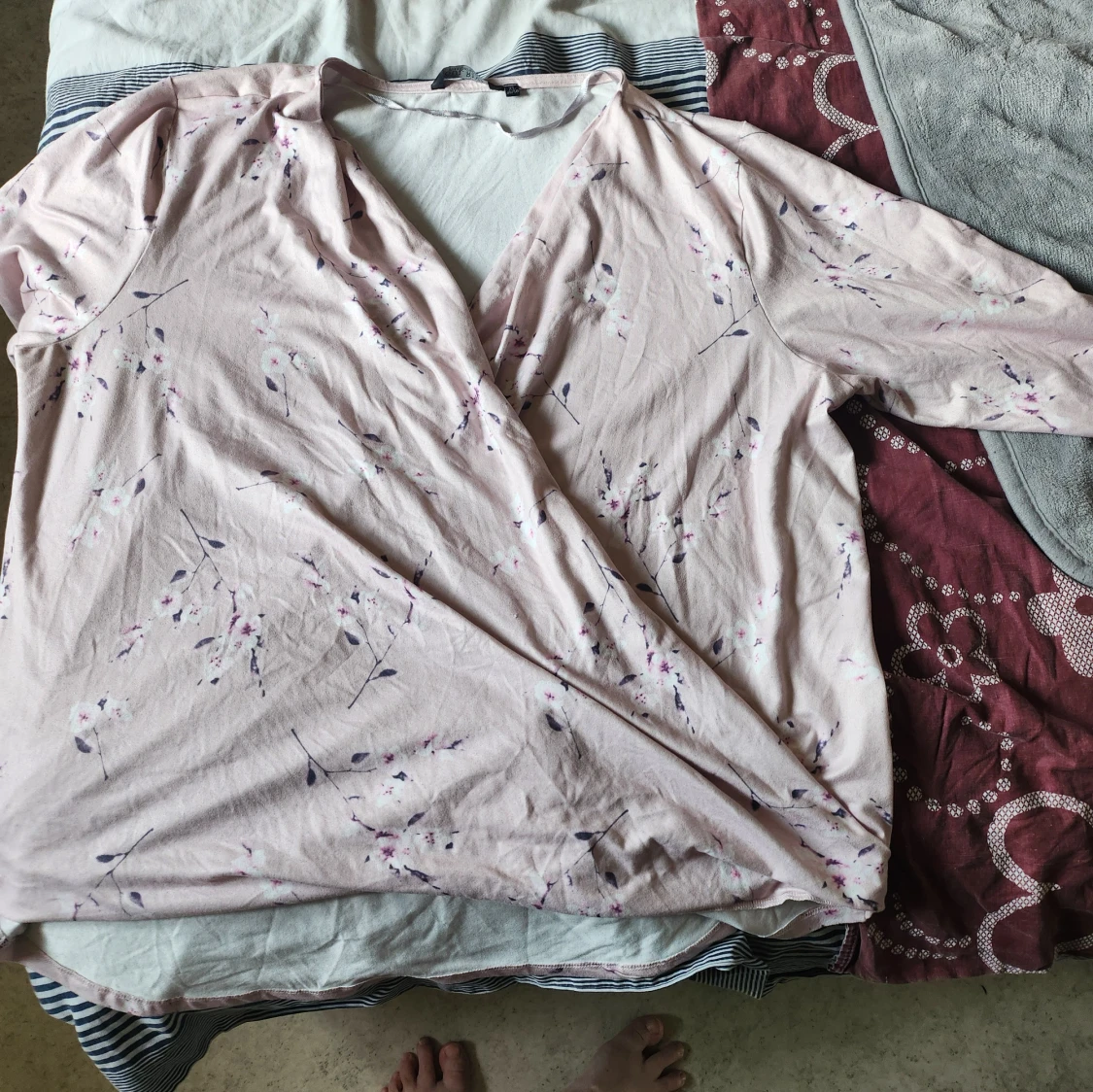 Ljusrosa omlottblus med blommigt mönster