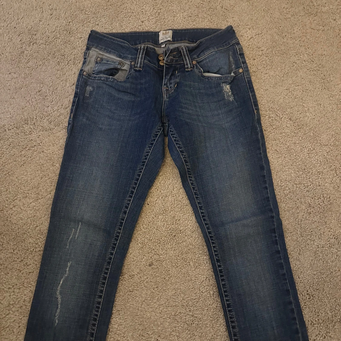 Blå  jeans med små slitningar