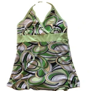 Grön mönstrad halterneck linnetopp - Snygg halterneck linnetopp med coolt retroinspirerat mönster i grönt, vitt, svart och beige. Toppen har omlott-skärning vid bysten och bred midjerem i ljusgrönt. Perfekt för dig som gillar färg och unika mönster.