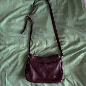 Etienne Aigner vinröd läderväska  - 🌸Färgen har skavts av på vissa ställen, men det är mest på kanterna. Annars bra skick. Materialet är äkta läder 🌸Skriv till mig för mått :) 