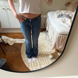 Lågmidjade only jeans  - Säljer ett par klassiska blå jeans med låg midja och bootcut-stil. Jeansen har fem fickor, dragkedja och knapp framtill. Perfekta för dig som gillar en tidlös look med lite utsvängda ben.