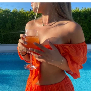 Orange offshoulder omlottopp med knyt och orange långkjol  - Säljer detta otroliga oranga set med långkjol och knyt topp som är så fin nu i sommar. Använd typ två gånger så det är som nytt. Säljer båda tillsammans. 