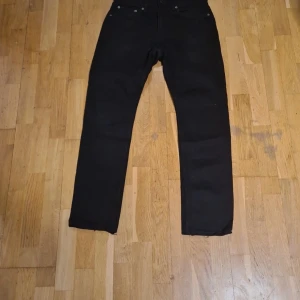 Svarta jeansbyxor från Lager 157 - Svarta jeansbyxor från Lager 157 med klassisk femficksdesign och raka ben. Byxorna har normal passform och är tillverkade i ett slitstarkt jeanstyg. Perfekta för en stilren och enkel look.