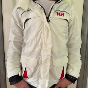 Vit Helly Hansen jacka - Snygg vit jacka från Helly Hansen. Jackan är i bra skick. Strl: S. Bara att höra av sig vid funderingar!
