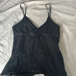 Svart linnetopp med rosett - Jättesöt och snygg vintage topp med fina daljer. Små pärlor och små broderingar där nere och en jättesöt knytning. Säljer pga att den inte passar!❣️