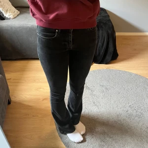 Svarta bootcut jeans low flare - Snygga svarta jeans med bootcut/flare modell och låg midja. Jeansen har klassisk femficksdesign, bälteshällor och dragkedja med knapp. Materialet är stretchigt jeans för en bekväm passform. Stretchiga så passar xs-S