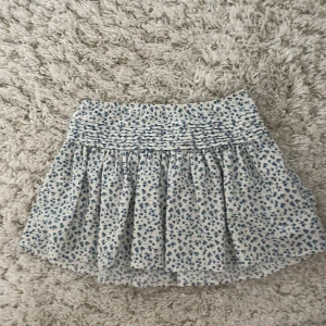 Vit & blå blommig kortkjol - Supersöt vit kortkjol med blått blommönster💙🌸 kjolen är i storlek 146/152 men passar xs💗 skriv gärna om ni har några frågor🥰