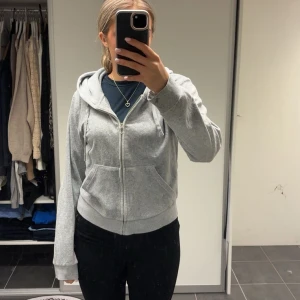 Grå hoodie från Juicy Couture - Säljer en klassisk grå hoodie från Juicy Couture med dragkedja framtill och två fickor. Tröjan har huva och ribbade muddar vid ärmslut och nederkant. Perfekt för en avslappnad stil. Storlek L men passar mig som vanligtvis brukar ha S💗