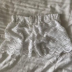 Vita spetsshorts - Säljer ett par vita shorts i spets med töjbar midja och fina volangdetaljer.🤍