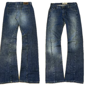 Blå bootcut jeans - Säljer ett par klassiska blå jeans med bootcut passform. Jeansen har fem fickor, normal midja och snygga slitningar framtill. Perfekta för dig som gillar en retrostil med lite utsvängda ben.