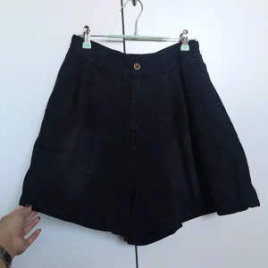 Svarta vida shorts med hög midja - Svarta & lite "washed" shorts med hög midja & vida ben. The "washed look" är väldigt vag & syns inte så mycket. De har fickor i sidorna, ett bak och resår baktill för extra komfort. Materialet är bomull & tyget tunt vilket gör det till ett bra vår/sommar-plagg. De är loose fit & ser nästan lite ut som en kjol också då benen är så vida. Strl oklart men uppskattar S-M. Midja 70cm & kan stretchas till 96cm. Längd 44cm & höft 130cm. 1-3cm give or take. Ord pris 289kr. Använda 2 gånger hemma, ⭐ skick