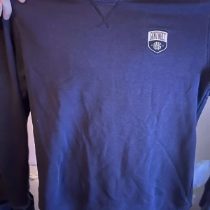 Mörkblå sweatshirt från Gant - En stilren mörkblå sweatshirt från Gant med liten broderad logotyp på bröstet. Tröjan har rund halsringning och långa ärmar. Perfekt för en avslappnad och klassisk look.