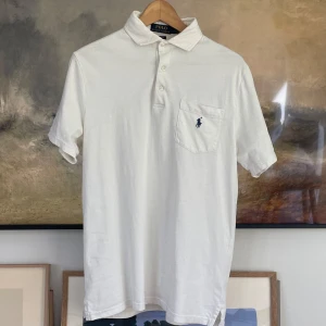Ralph Lauren Piké - Säljer en snygg Piké från Ralph Lauren med ficka perfekt till sommarn| Skick: 8/10 Storlek: S | Mått: Axelbredd: 44cm Axel till midja: 59cm Ärmen: 24cm | Nypris: 1595kr Mitt pris: 359kr | Tveka inte på att ställa frågor privat!💯