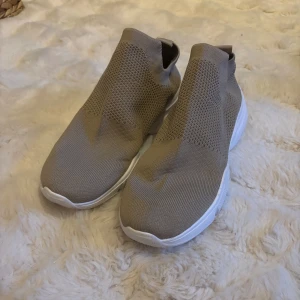 Beige slip-on sneakers med vit sula - Säljer ett par beigea slip-on sneakers från lager 157. Super sköna skor att ha till vardags samr träning