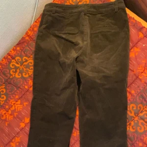 Bruna manchesterbyxor med bootcut - Snygga bruna manchesterbyxor med bootcut och normal passform. Byxorna har hällor för bälte och klassisk design, perfekta för dig som gillar retrostil. Materialet är mjukt och ger en skön känsla.