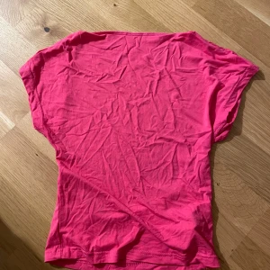 Rosa t-shirt från SHEIN - En enkel rosa t-shirt från SHEIN med korta ärmar och rund halsringning. T-shirten är tillverkad i ett mjukt bomullsmaterial och har en klassisk passform. Perfekt för en avslappnad stil.