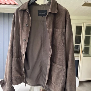 Brun manchester overshirt från Paul & Friends från NK - Skrin overshirt i manchester från Paul & Friends köpt från NK Jackan har tre stora fickor framtill, knäppning med knappar och klassisk krage. Perfekt för lager-på-lager och ger en avslappnad stil.