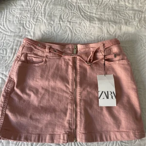  Super söt rosa jeanskjol från Zara 💕 - Säljer en ljusrosa jeanskjol från Zara med dragkedja framtill och bälteshällor. Kjolen har fickor både fram och bak samt en snygg, enkel design. Perfekt att matcha med en enkel topp eller hoodie.