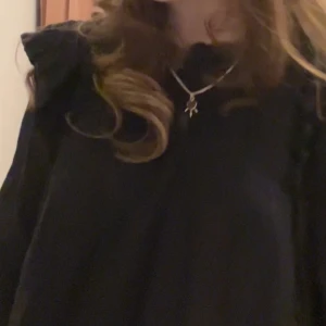 Svart blus - Svart blus från Zara med spetsdetaljer och volang.