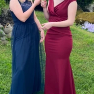 Vinröd balklänning  med v-ringning - Säljer min  vinröd balklänning  med  v-ringning och figurnära passform. Från bubbleroom  nypris 900 kr endast använd 1 gång 