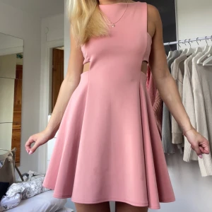 Klänning - Somrig klänning i en jättefin rosa färg, den är lite öppen på sidorna och ser lika dan ut i ryggen som framtill, jätte lent ”sidenaktikt” material, perfekt till sommaren!