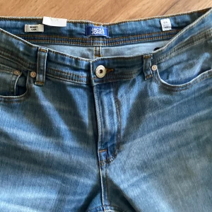 Jackǥ Jones  - Säljer ett par blå skinny jeans från Jack & Jones. Klassisk femficksmodell med dragkedja och knapp i midjan. Jeansen har en lätt tvättad look och smal passform hela vägen ner. Perfekta för dig som gillar en tajtare stil.