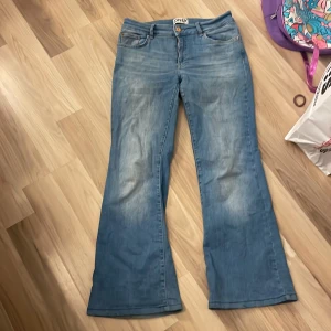 Blå bootcut jeans från ONLY - Säljer ett par klassiska blå bootcut jeans från ONLY. Jeansen har fem fickor, normal passform upptill och utsvängda ben. Perfekta för dig som gillar en retroinspirerad look. Stängs med knapp och dragkedja.