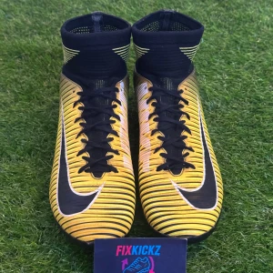 Nike Mercurial fotbollsskor i gult och svart - Säljer ett par Nike Mercurial fotbollsskor i gult och svart med vita detaljer och svarta snören. Skorna har högt skaft, tydliga ränder och mönstrad ovansida. Perfekta för dig som vill sticka ut på planen!