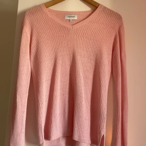 Ljusrosa stickad tröja från Marc O'Polo - Säljer en ljusrosa stickad tröja med v-ringning och lång ärm. Tröjan har ett diskret ribbat mönster och är mjukt. 