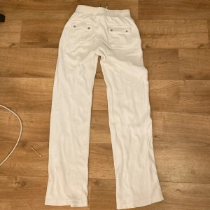 Vita mjukisbyxor Juicy Couture XS - Vita mjukisbyxor från Juicy Couture i storlek XS. Ena fickan där bak saknar en knapp men det är inget som påverkar plagget eller ens tänker på. Kommer inte till användning längre. 