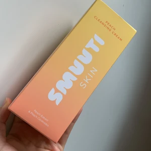 Smuuti Skin Peach Cleansing Cream - Mild rengöringskräm med persikaextrakt och persikaceramider som stärker hudbarriären och ger glow. Vegansk och parfymfri formula med låg pH, passar perfekt för dig som vill ha mjuk och fräsch hud. Kommer i en snygg persikofärgad och gul förpackning.HELT NY!!!
